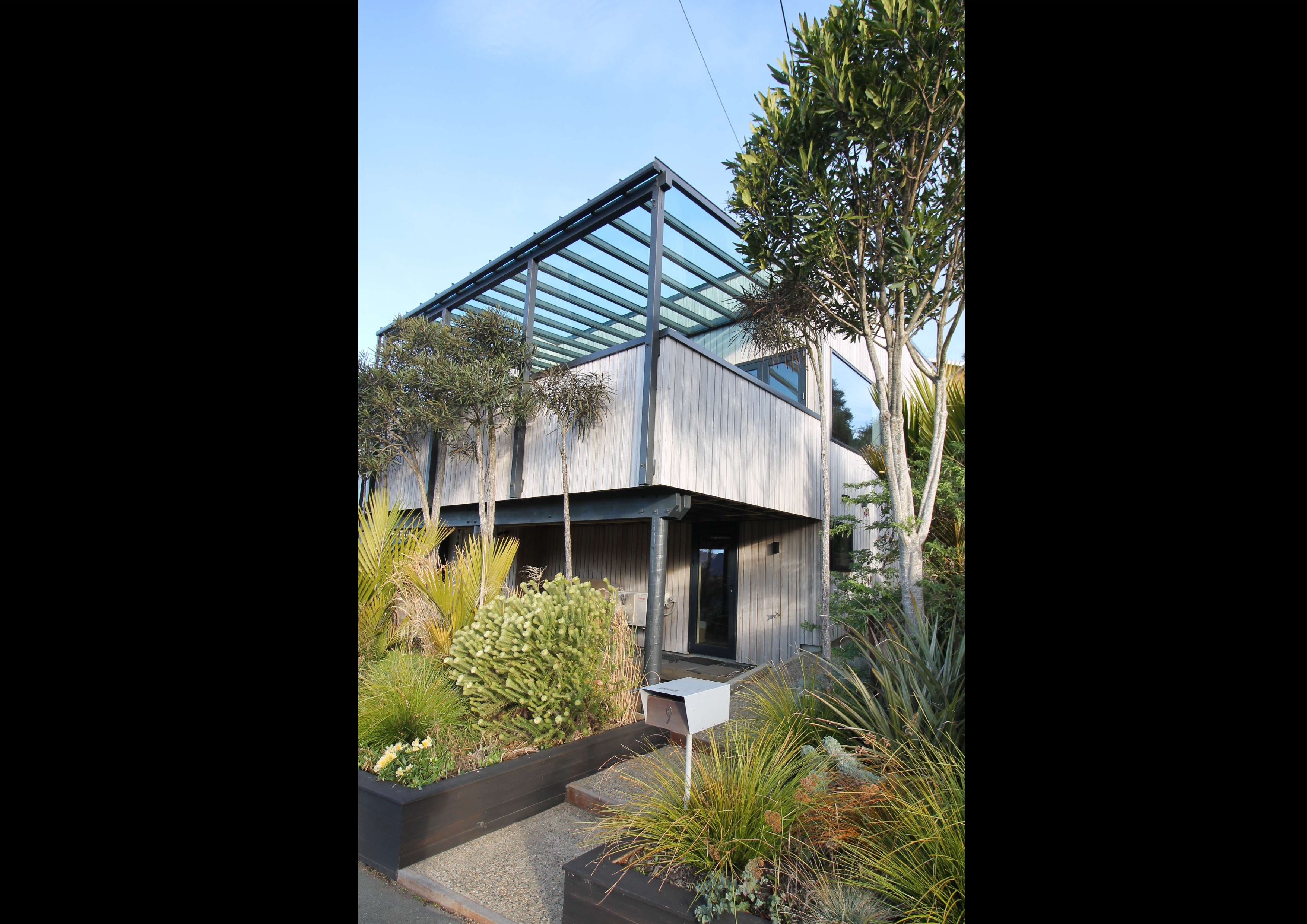 Abodo-vertical-weatherboards-enclosed-deck-balustrade-aluminium-veranda-glass-roof-entry-landscape