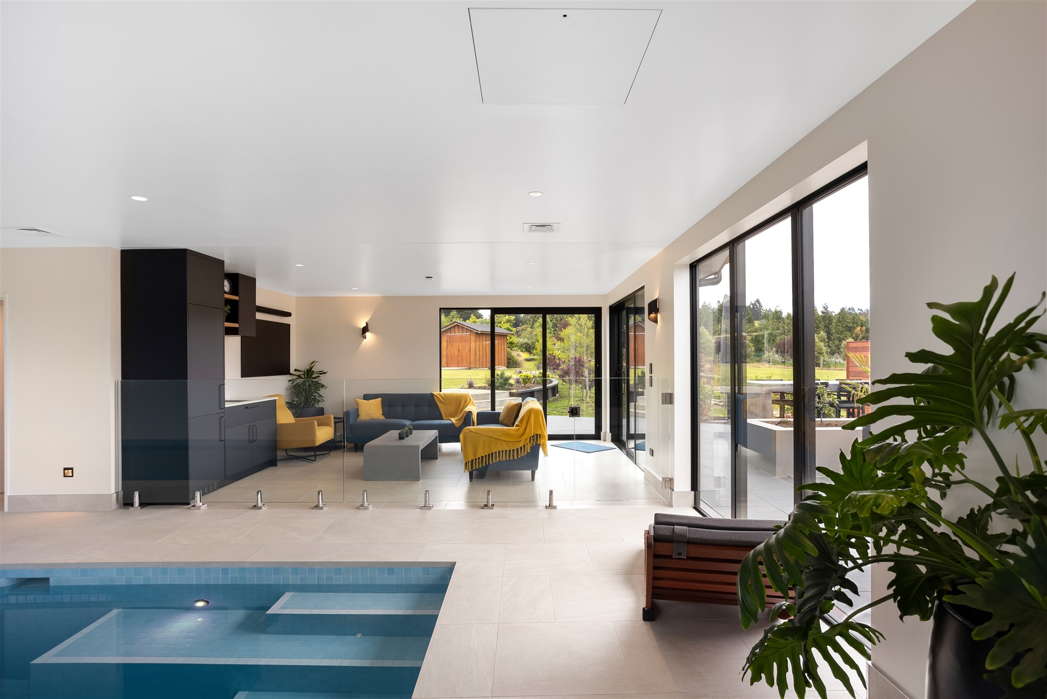 Indoor-tiled-pool-steps-glass-balustrade-indoor-living