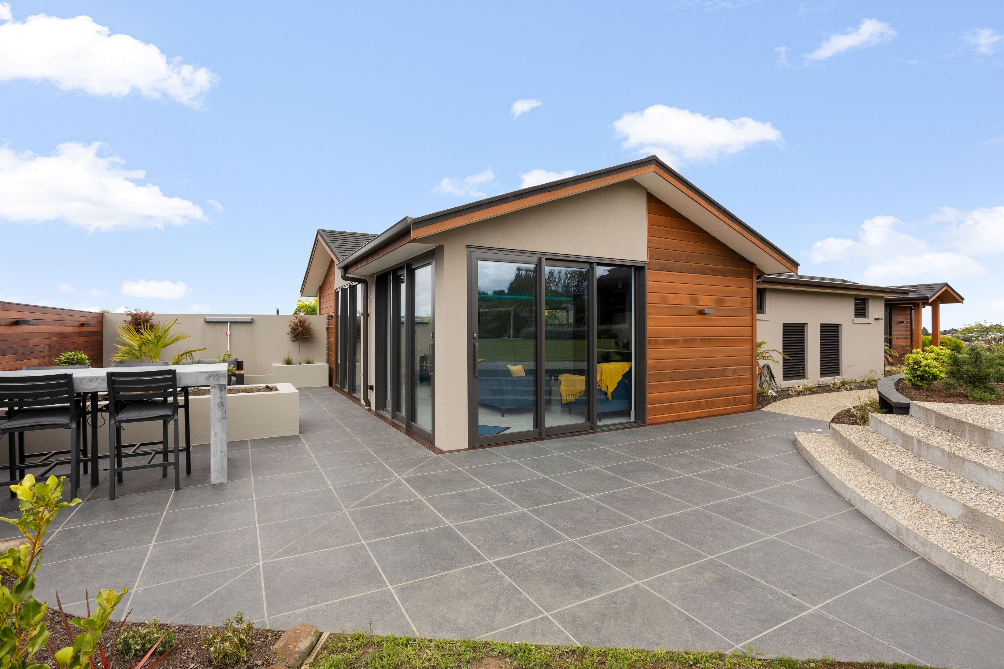 Pool-house-outdoor-courtyard-patio-paving-seating-cedar-stacker-doors-concrete-steps