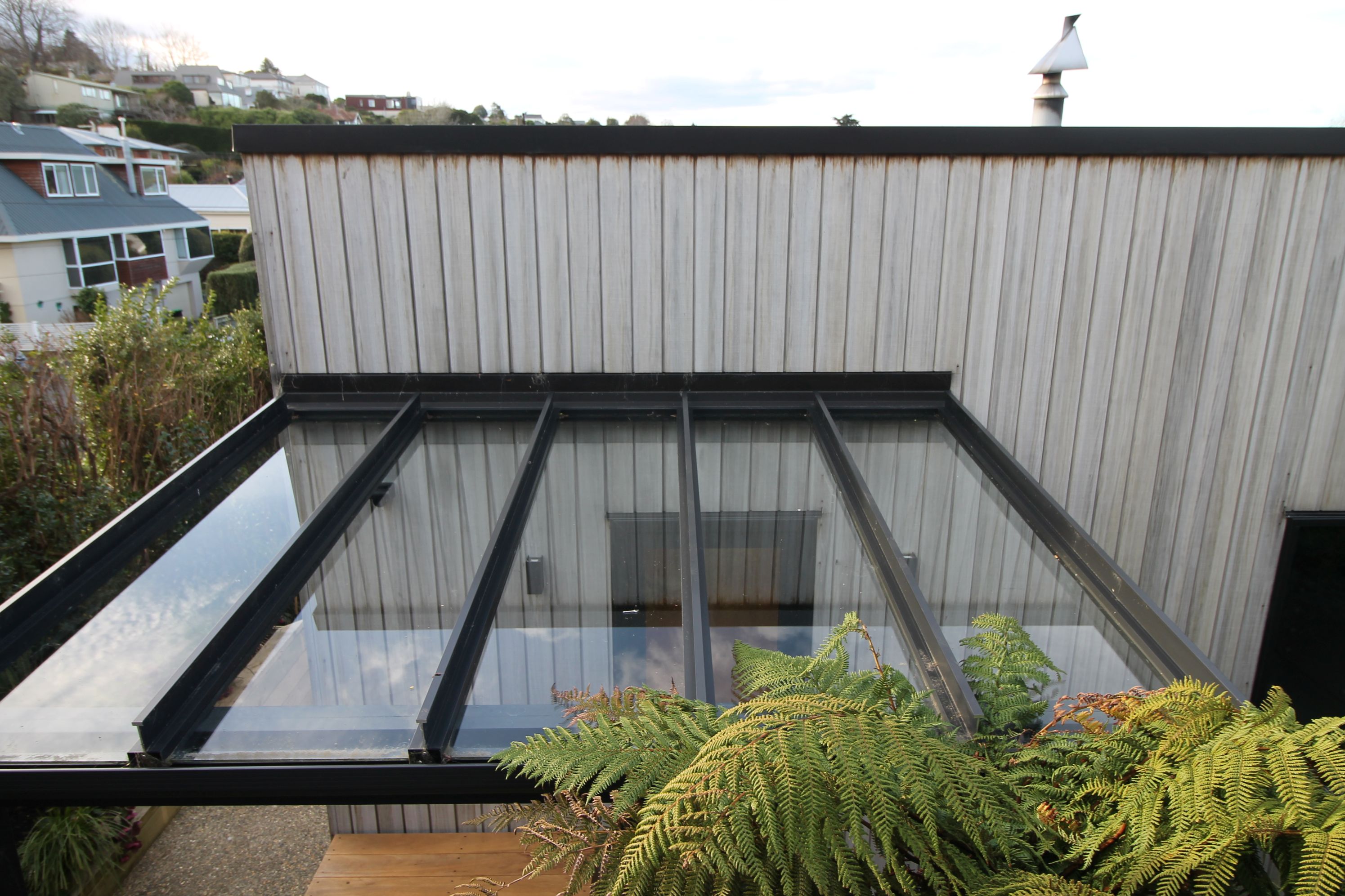 Timber-weatherboard-aluminium-framed-roof-glazing-back-door-shelter-parapet-flat-roof