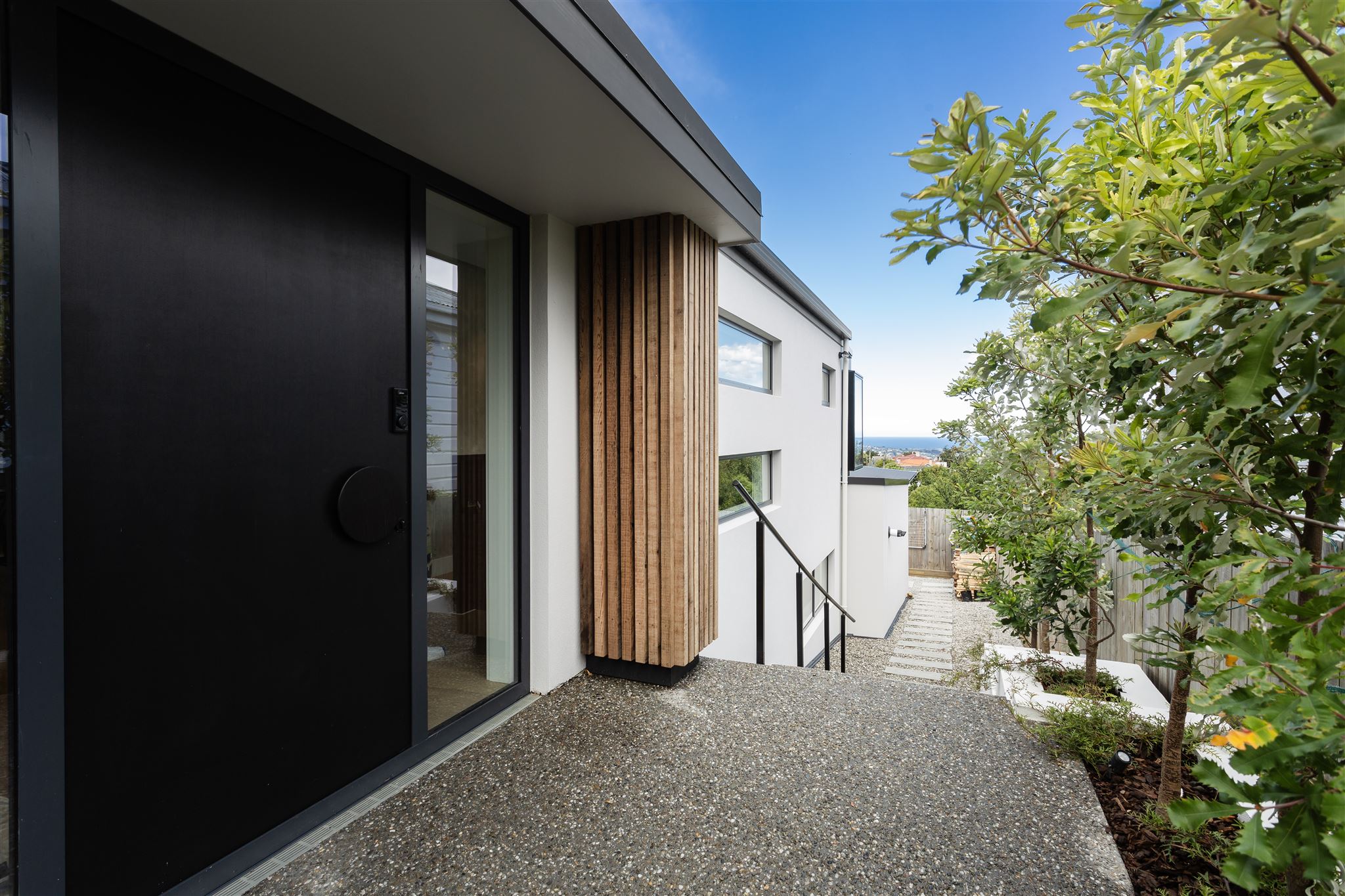 entry-door-exposed-concrete-path-landscaping-cedar-sto-render